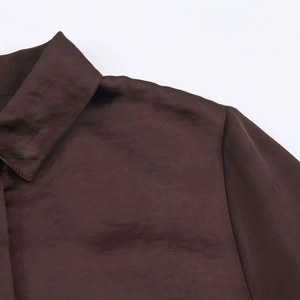 Close-up of dark brown silk satin shirt showing pointed collar and smooth fabric texture