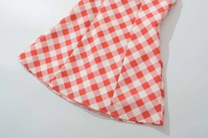 Close-up of the red and white gingham pattern and hemline on a summer A-line dress