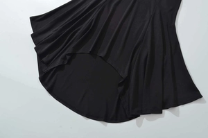 Detailopname van de zwarte asymmetrische zoom met geplooide drapering van zachte stof