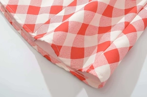 Close-up detail of red and white gingham fabric showing clean hem stitching and texture