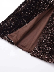 Close-up of sparkling dark brown sequins and smooth inner lining on a midi skirt
