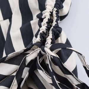 Detailed view of striped shirt fabric texture with pleated design and tie-up bow detail