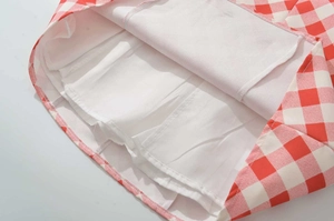 Detailed close-up of red and white gingham fabric with high-quality white inner lining