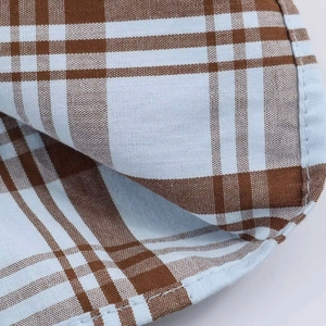 Macro detail of blue and brown checkered poplin fabric with neat overlock stitching