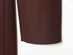 Gros plan détaillé montrant la texture sergé fine et les coutures des manches marron