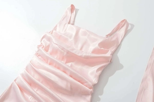 Dettaglio dell'abito in raso rosa con scollo quadrato ed eleganti arricciature
