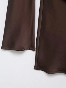 Gros plan sur le tissu en satin marron foncé et les finitions de la robe de soirée