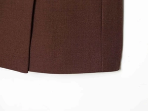 Gros plan détaillé sur le tissu sergé marron foncé et les coutures de la robe blazer
