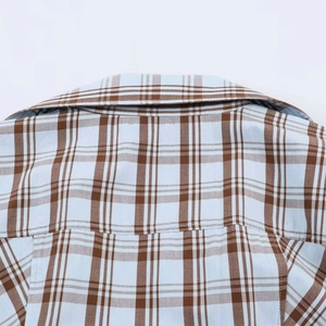 Close-up of the collar and fine stitching on the blue and brown checkered poplin shirt