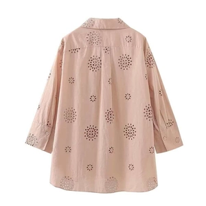 Detail of pink eyelet embroidery on a long-sleeved casual shirt with a classic collar
