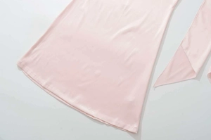 Dettaglio dell'orlo dell'abito in raso rosa e nastro laterale con cuciture lisce