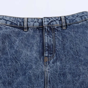 Detailed macro view of deep blue washed denim skirt waistband with contrast orange stitching