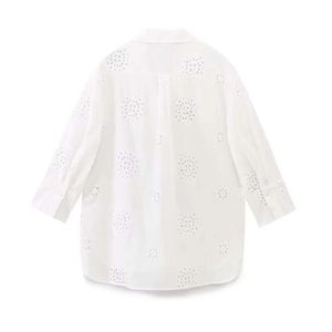 Detail of white cotton shirt with intricate floral broderie anglaise embroidery and round hem