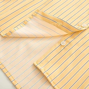 Detailed macro view of yellow and white vertical stripes and stitching on a lightweight shirt