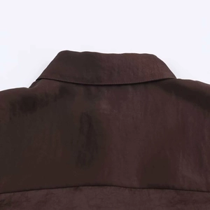 Detailed view of dark brown satin textured shirt collar with high quality stitching