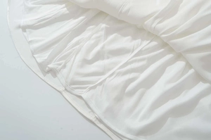 Détail du tissu de robe blanche montrant les coutures et la doublure opaque