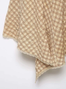Détail du tissu seersucker à carreaux havane avec bordure en dentelle et ourlet à volants