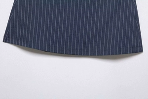 Détail de l'ourlet incurvé et des fines rayures blanches sur le tissu bleu marine