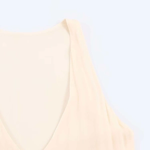 Detail of light beige seamless V-neck midi dress featuring smooth laser-cut edges and soft knit