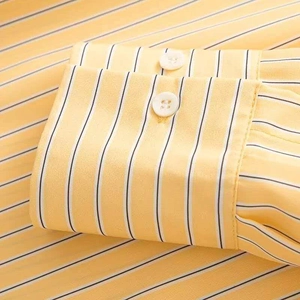 Detailed macro shot of yellow and white striped shirt cuff with two white buttons