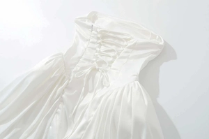 Détail d'une robe en satin blanc avec laçage corset élégant et fermeture éclair invisible
