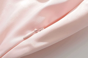 Dettaglio ravvicinato del tessuto rosa e della cerniera invisibile in tinta di alta qualità