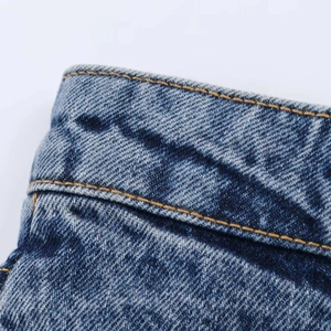 Detail of high waist denim skirt waistline with vintage wash and double yellow stitching