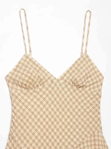 Détail d'une robe vintage à carreaux beige avec texture seersucker et fines bretelles