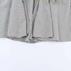 Détail de l'ourlet en vichy noir et blanc montrant la texture tissée et les plis