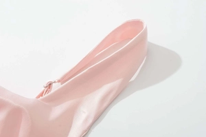 Dettaglio ravvicinato del tessuto dell'abito rosa chiaro con trama liscia e cuciture rifinite