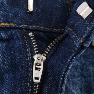 Detail of high waist denim skirt with YKK metal zipper and silver hook closure