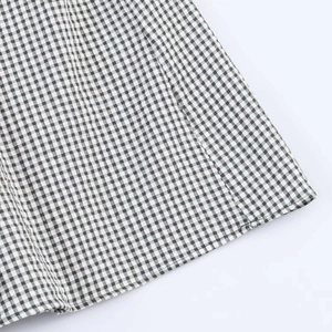 Gros plan sur le tissu vichy noir et blanc avec coutures fines et texture en coton doux