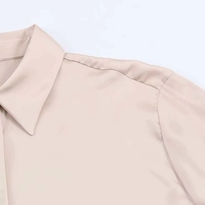 Detail of elegant champagne satin shirt collar and shoulder with smooth silk texture