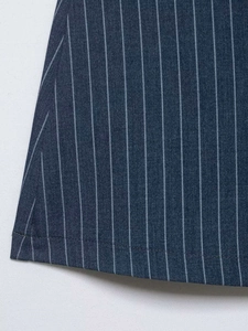 Gros plan sur un tissu bleu marine à rayures avec couture d'ourlet et texture sergée
