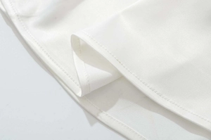 Gros plan sur l'ourlet d'une robe blanche avec des détails de couture à double aiguille