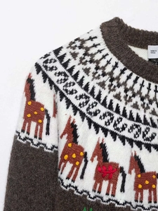 Détail du motif jacquard cheval vintage et du col rond sur le pull en maille marron