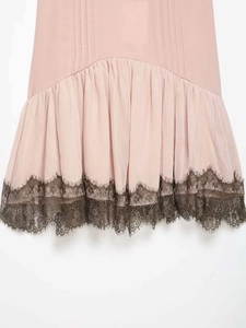 Detail of light pink pleated dress hem with dark brown eyelash lace trim stitching