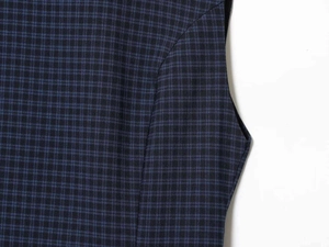 Dettaglio del tessuto a quadri blu navy e cuciture precise sull'abito senza maniche