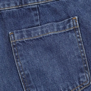 Detailed macro shot of dark blue denim jeans showing double orange stitching and texture