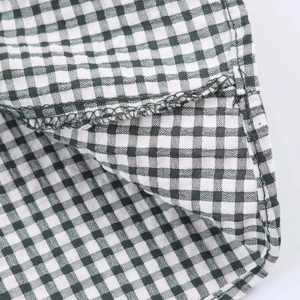 Gros plan sur les coutures surjetées et le motif à carreaux noir et blanc de la robe