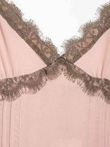Close-up of pale pink chiffon dress featuring V-neckline with delicate dark lace trim