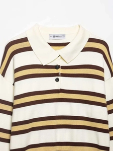 Detail of polo collar and striped knit fabric with black buttons and brand label