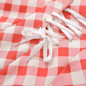 Red and white checkered dress featuring elegant halter neck straps and metallic eyelet details