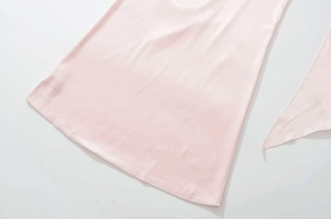 Dettaglio della trama del tessuto setoso rosa e cuciture su un abito estivo