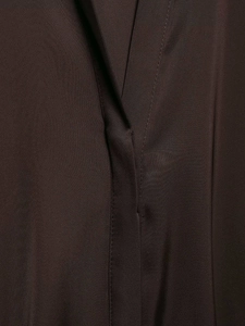 Gros plan sur le tissu en satin marron montrant la texture soyeuse et les coutures