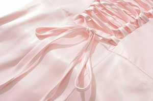 Dettaglio del corsetto posteriore in raso rosa con lacci intrecciati dell'abito
