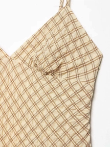 Détail de robe à carreaux avec motif écossais orange-marron et texture de tissu plissé