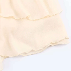 Detailed macro view of cream-colored tiered chiffon ruffles with fine lockstitch edge finish