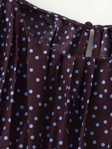 Détail du col plissé sur un chemisier bordeaux à pois avec bouton au dos élégant