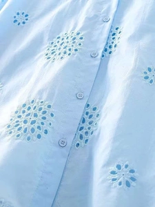 Close-up of light blue summer set featuring white floral eyelet embroidery and buttons